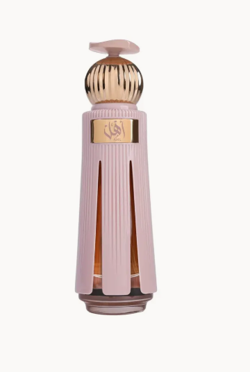 ahl ahmed al magribi A luxury perfume bottle with a ribbed light pink body, a gold accent plate featuring Arabic calligraphy, and a matching pink cap, set against a plain off-white background